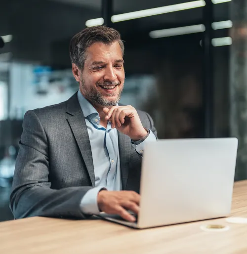 Middle aged business male professional smiling while using laptop
