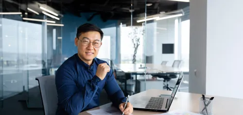 Business man in his 50's sitting in the office smiling