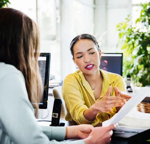 Woman in yellow shirt speaking with her client