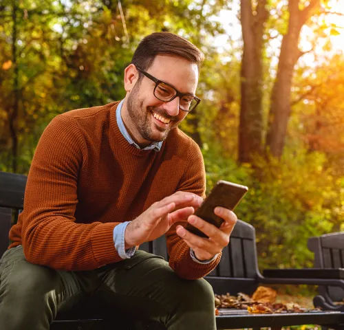 Professional middle aged man smiling while looking at his phone