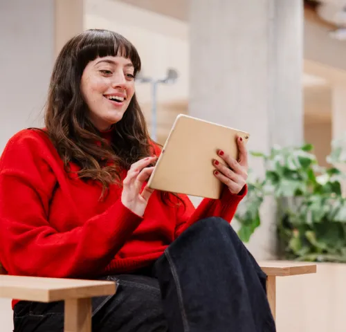 Girl in red sweater looking at her iPad