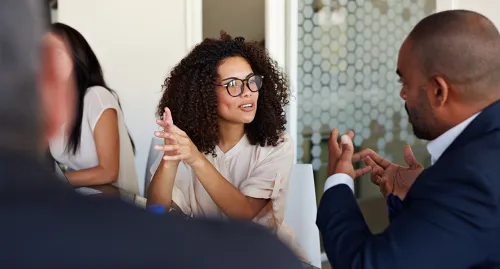 A group of male and female coworkers talking in a meeting