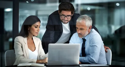 Group of coworkers gathered around the computer