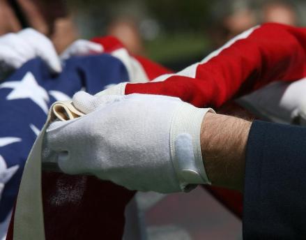 Military servicemen folding the American flag