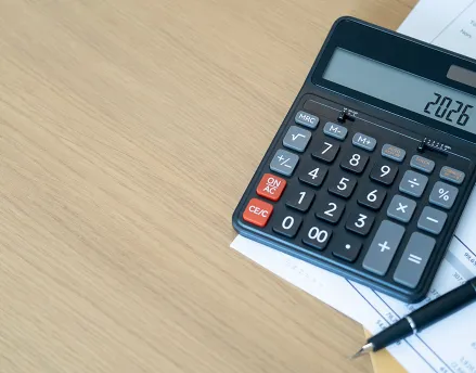Calculator on the table with a pen and paper