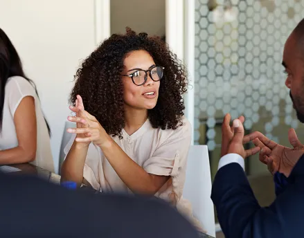A group of male and female coworkers talking in a meeting