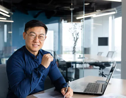 Middle aged man in blue button down sitting at his desk