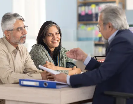 Middle aged male advisor meeting with his retiree couple clients