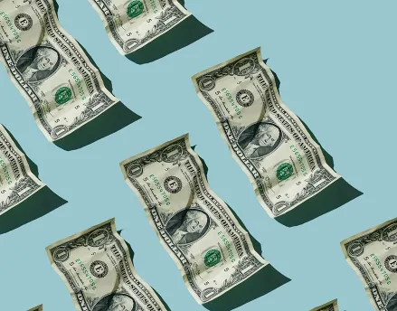 Wrinkled one dollar bills stacked in rows