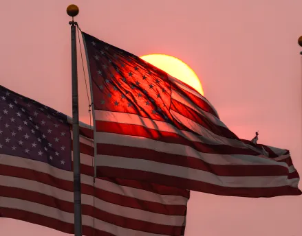 Four American Flags waving in the sunset