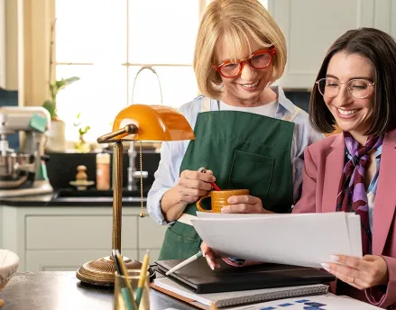 Elderly woman in her kitchen speaking with her financial advisor