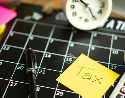 Calendar with a clock and sticky notes about taxes
