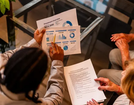 Financial advisor reviewing documents with elderly clients